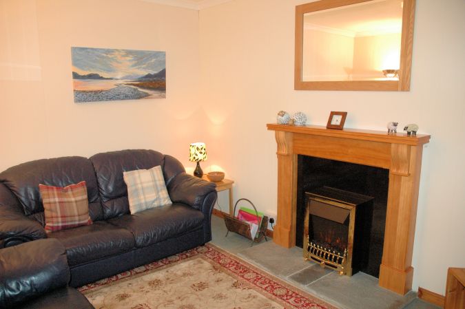 Bruaich Cottage, Lochcarron, has a cosy and homely living room with a traditional fireplace.